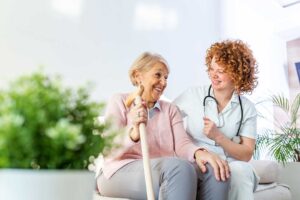 Older adults participate in seated exercise and light stretching in a bright assisted living activity room.