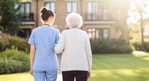 Adult family members discussing care plans with a staff member and an elderly resident in a cozy communal lounge.